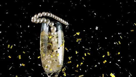 confetti falling over pearl beads falling in champagne glass against black background