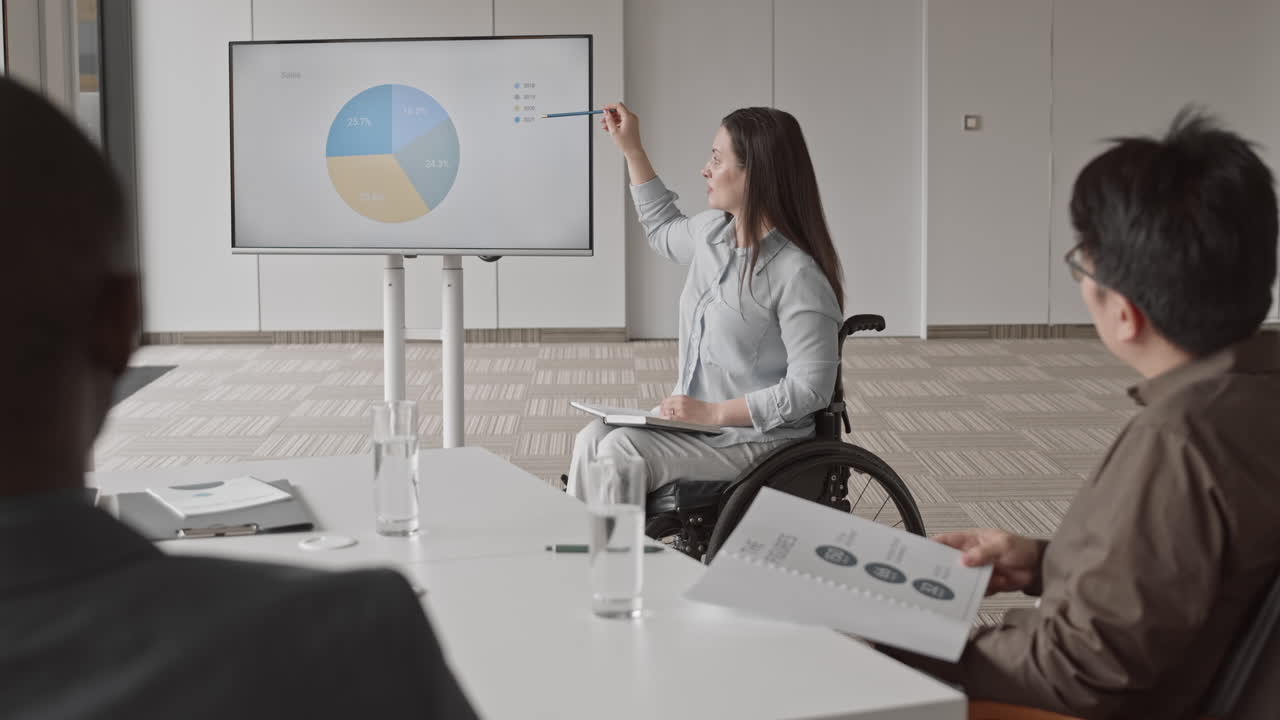 Businesswoman with Disability Showing Annual Report to Coworkers