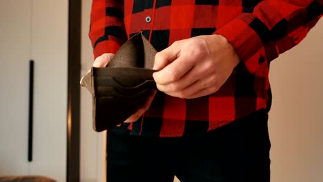 man angry because of lack of money. close up of male's hands showing empty lether wallet with no money. finance business bankruptcy concept.