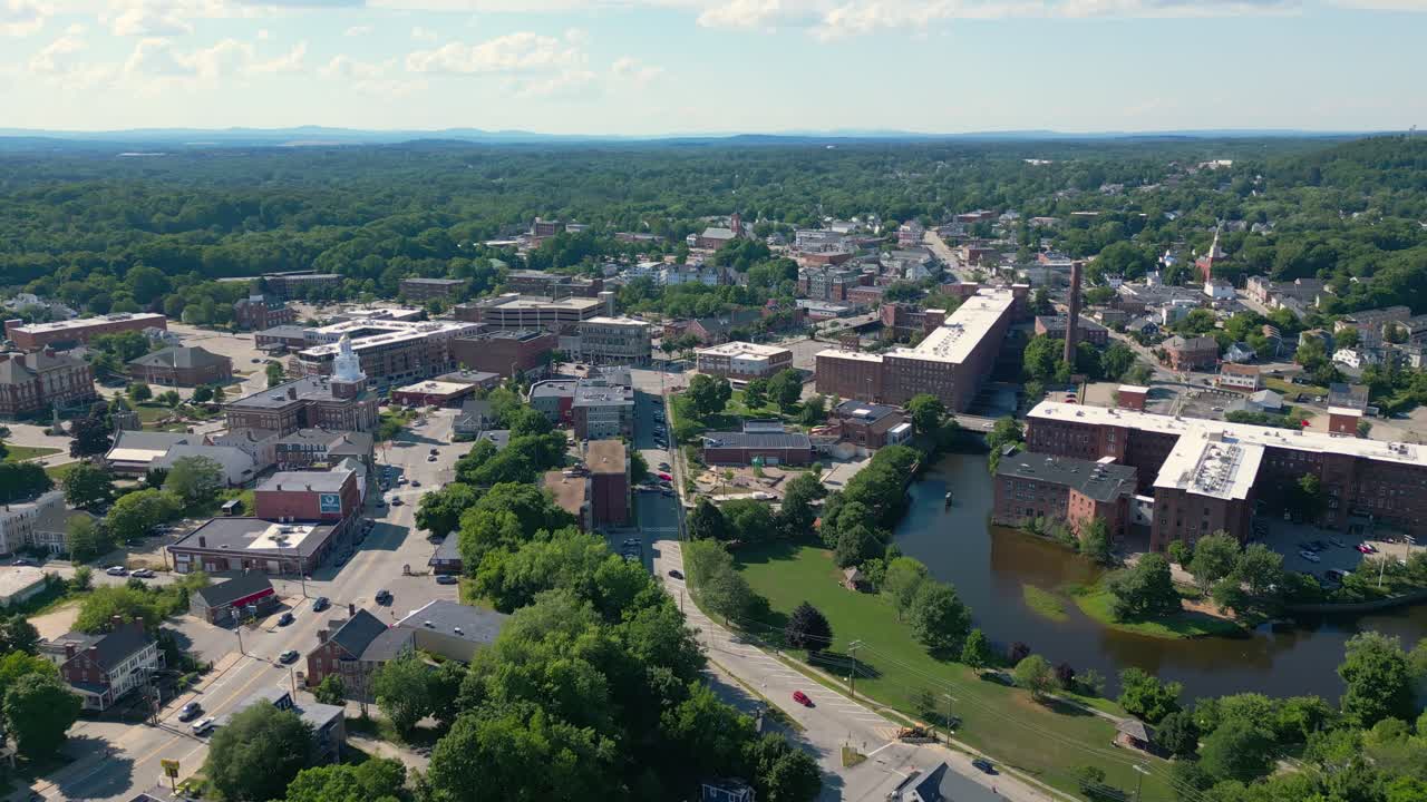 Volo lento di drone che si avvicina al mulino nel centro storico di Dover, New Hampshire, USA. È una luminosa giornata estiva e c'è poco traffico sulla strada principale.