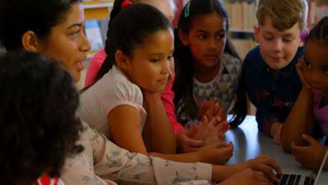 Asiatische-Lehrerin-Unterrichtet-Schulkinder-In-Der-Schulbibliothek-4k