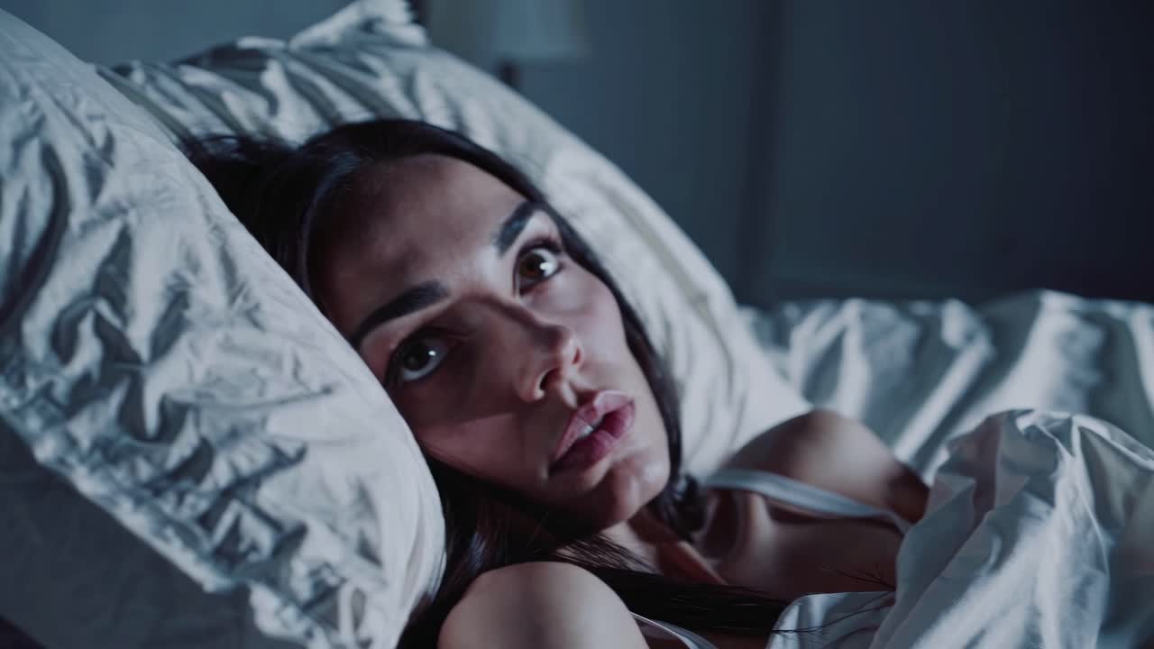 Close-up video angle of a woman sleeping peacefully in low light, capturing a serene nighttime