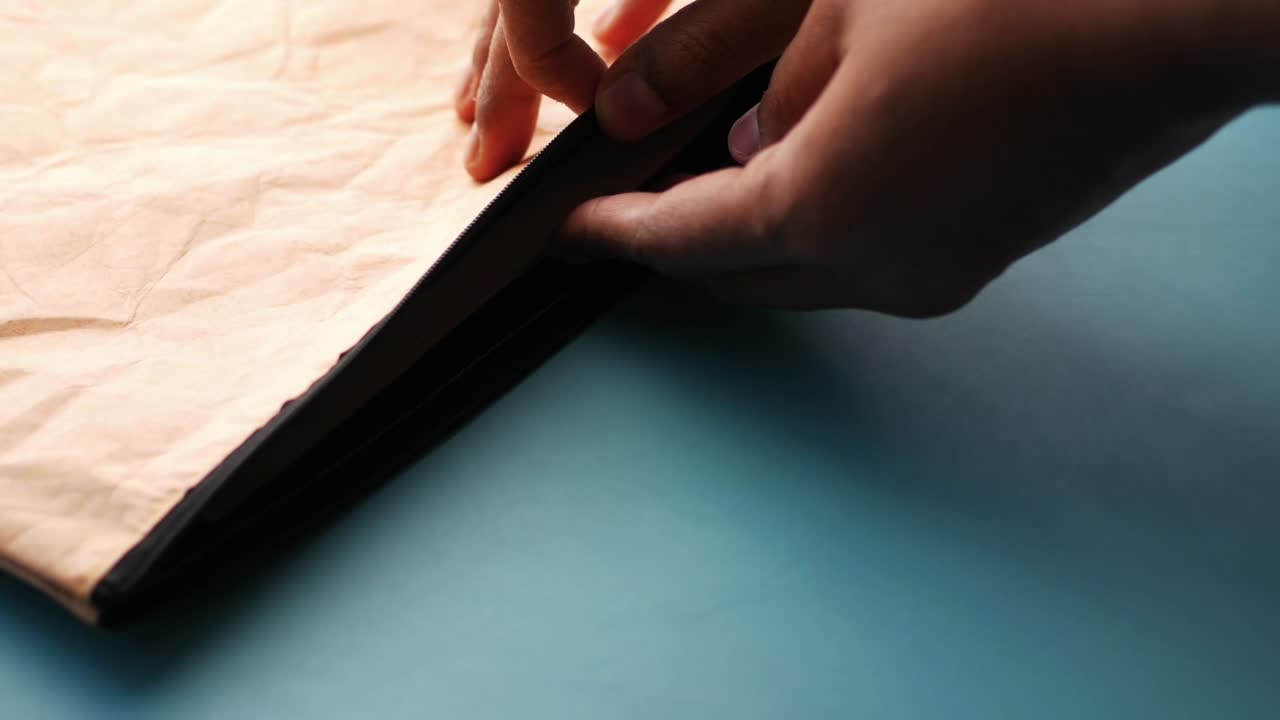 mettendo della carta in una borsa sul tavolo