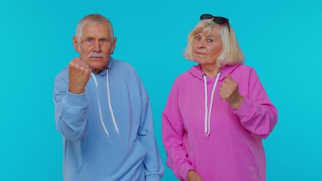 Aggressive-senior-woman-granny-with-man-grandfather-trying-to-fight-at-camera,-shaking-fist,-boxing