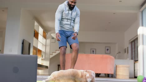 Fröhlicher-Afroamerikanischer-Mann-Streichelt-Hund-An-Deck-Im-Sonnigen-Garten,-Zeitlupe