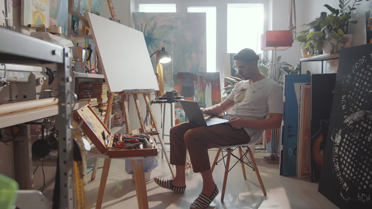 artista masculino usando una computadora portátil en el estudio