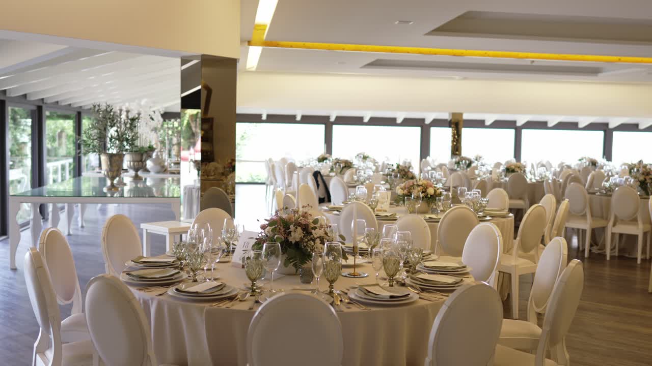 luxury banquet room prepared for wedding with round tables and flowers