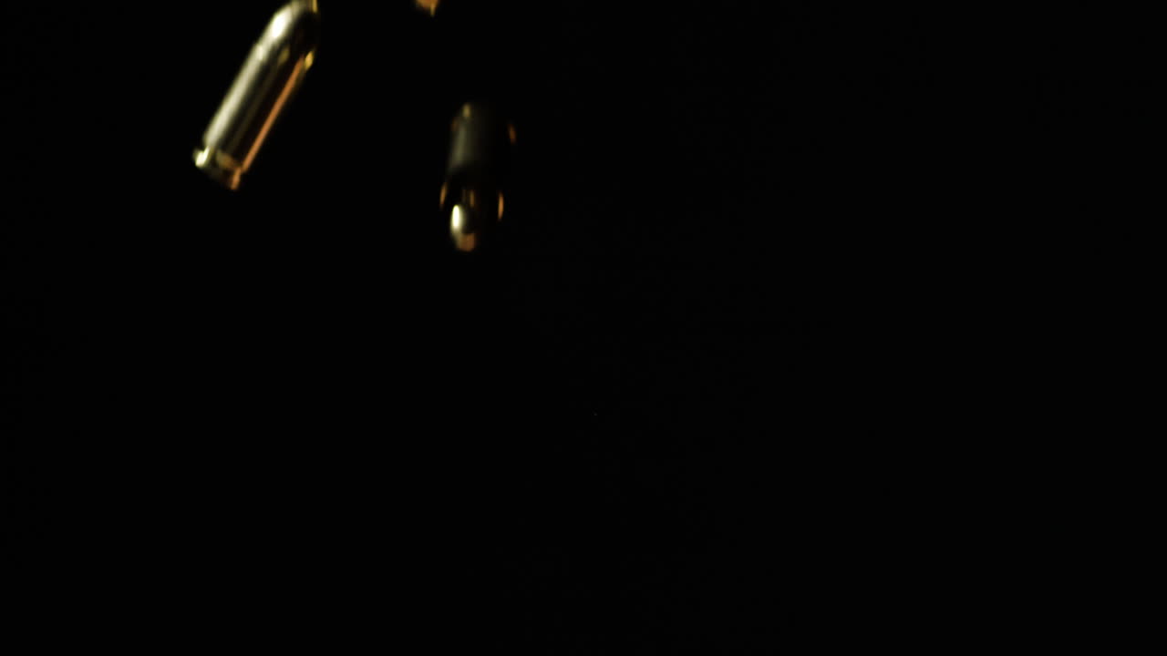 balas cayendo en cámara lenta frente al fondo negro, estática de cerca