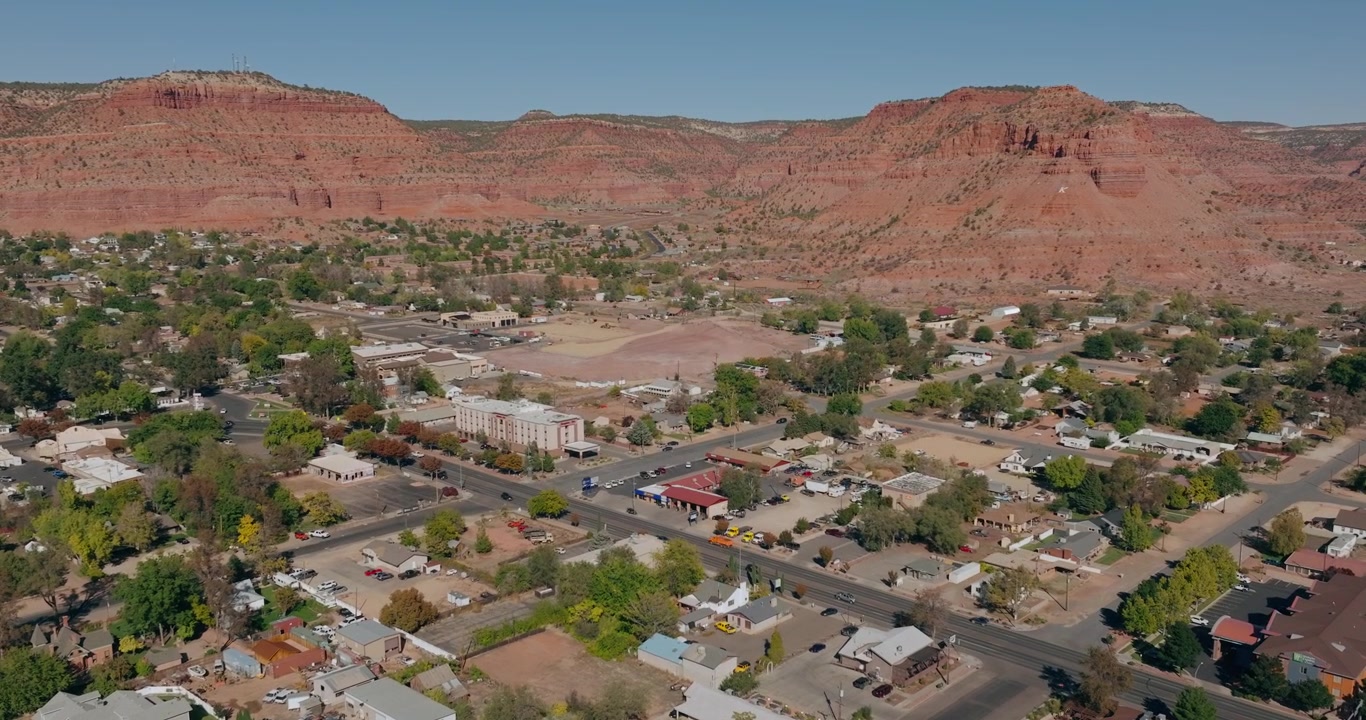 Ripresa aerea con dolly della griglia urbana di Kanab, Utah, con mesas desertiche e colline di arenaria