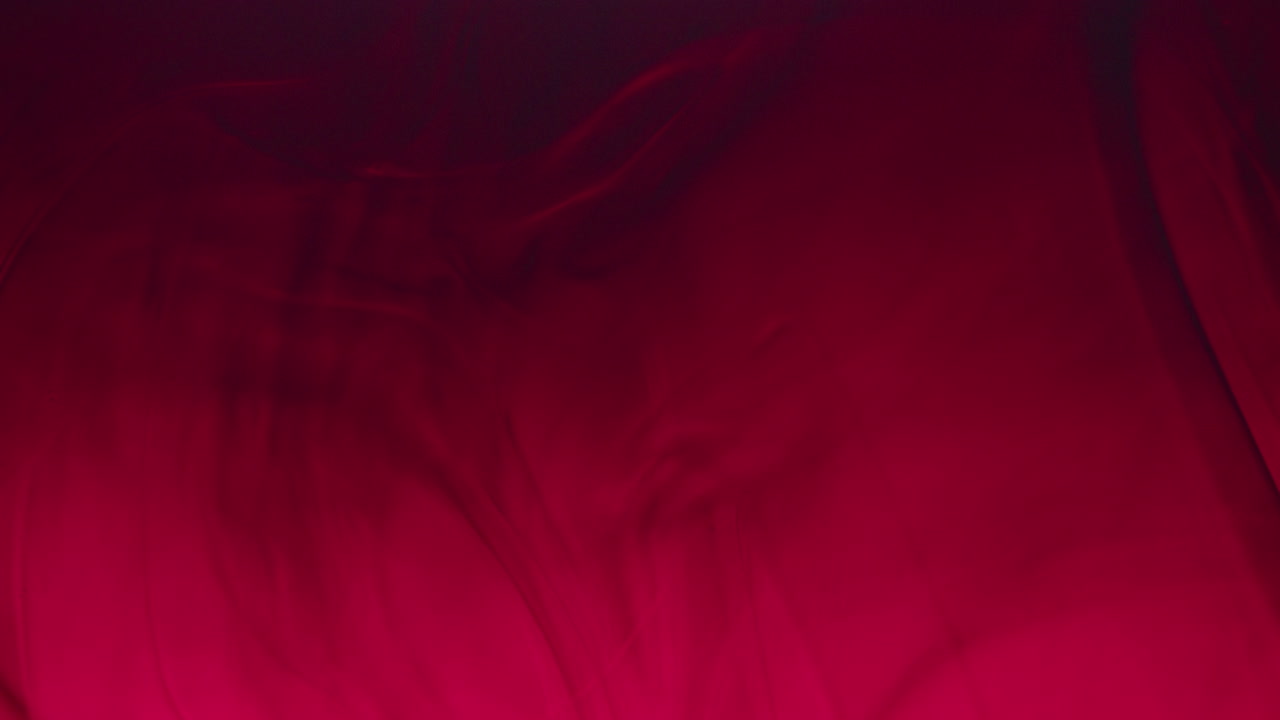 macro al rallentatore di fluido rosso e olio che vortice sott'acqua