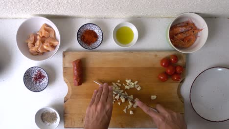 fast timelapse of male hands cutting garlic on wooden cutting board