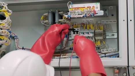 electrical engineer working check the electric current voltage and overload at front of load center cabinet or consumer unit for maintenance in main power distribution system room.