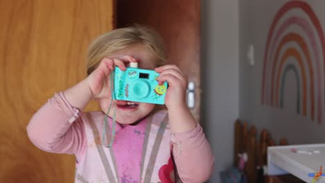 adorable toddler girl playing with toy camera