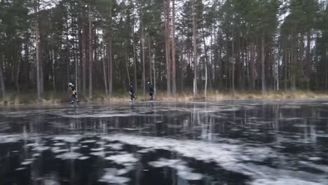 dynamic side view of three friends ice skating on a wild lake in latvia