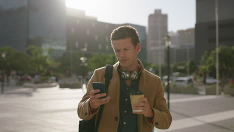 Retrato-De-Un-Joven-Y-Apuesto-Hombre-De-Negocios-Caucásico-Enviando-Mensajes-De-Texto-Navegando-Usando-Una-Aplicación-De-Redes-Sociales-Para-Teléfonos-Inteligentes-Relajado-Bebiendo-Café-En-La-Ciudad-Antes-De-Trabajar