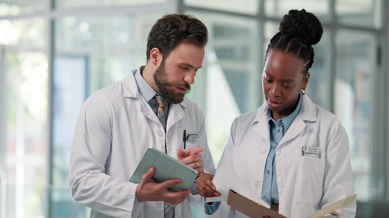 Two Diverse Doctors Discussing Medical Information on a Tablet