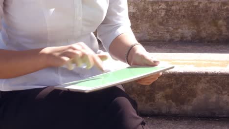mujer de negocios asiática usando su tableta afuera