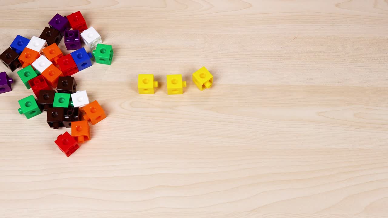 manos montando cubos en una mesa de madera