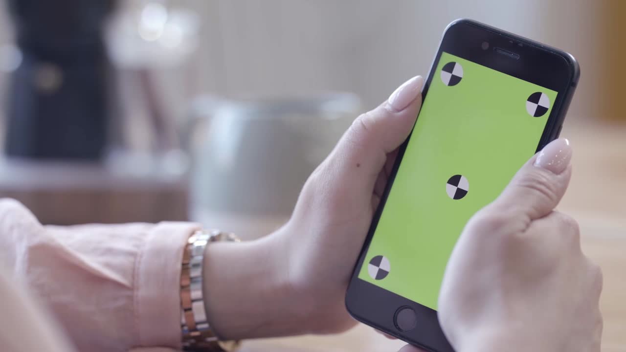 mujer usando un teléfono inteligente con una pantalla verde