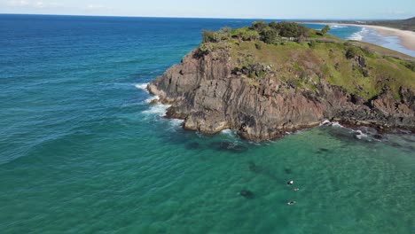 bird's eye view of norries headland with rocky cliff - surfing at cabarita beach in nsw, australia