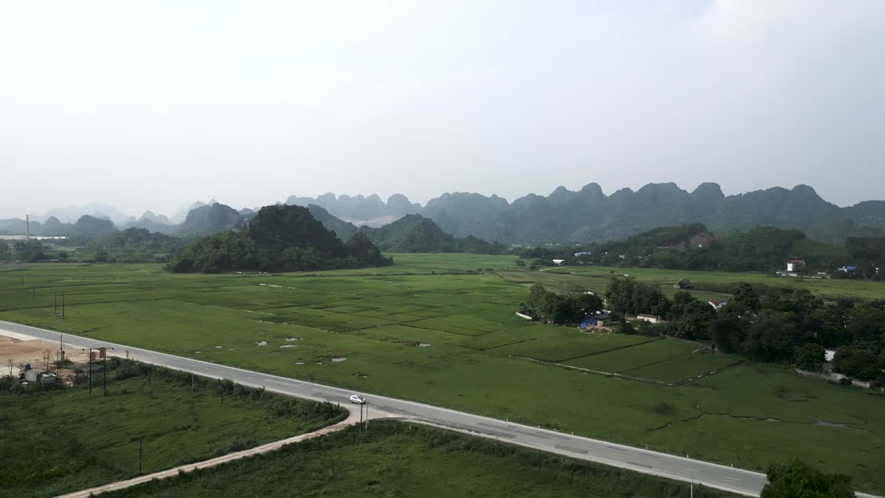 Panoramic View of Rural Vietnamese Landscape with Rice Paddies and Mountains