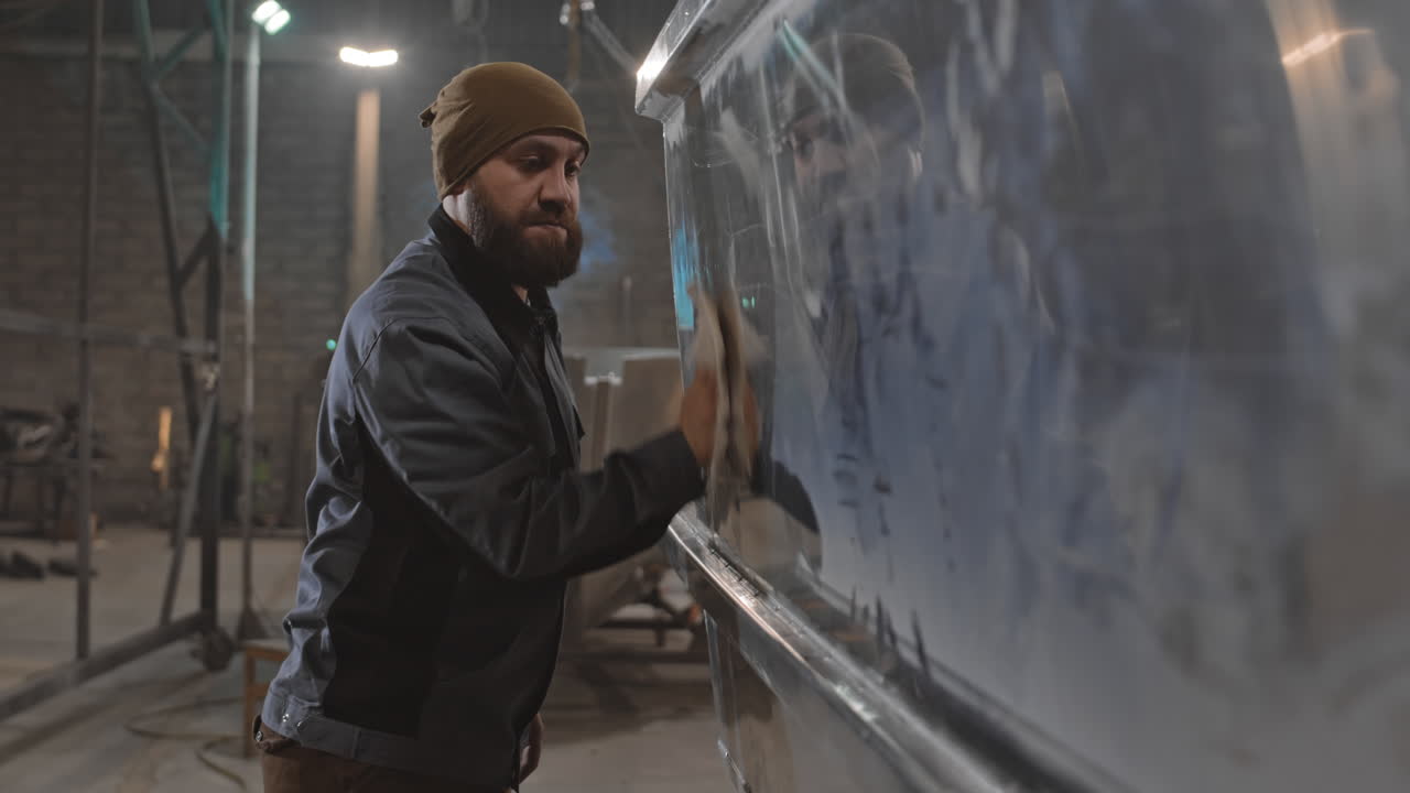Man cleaning metal in workshop