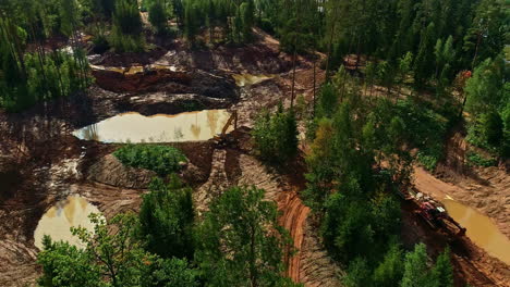 Aerial-drone-fly-above-flooded-brown-water-excavator-machine-mixes-soil-forest-with-pines,-establishing-shot-of-working-location,-countryside-environment,-construction