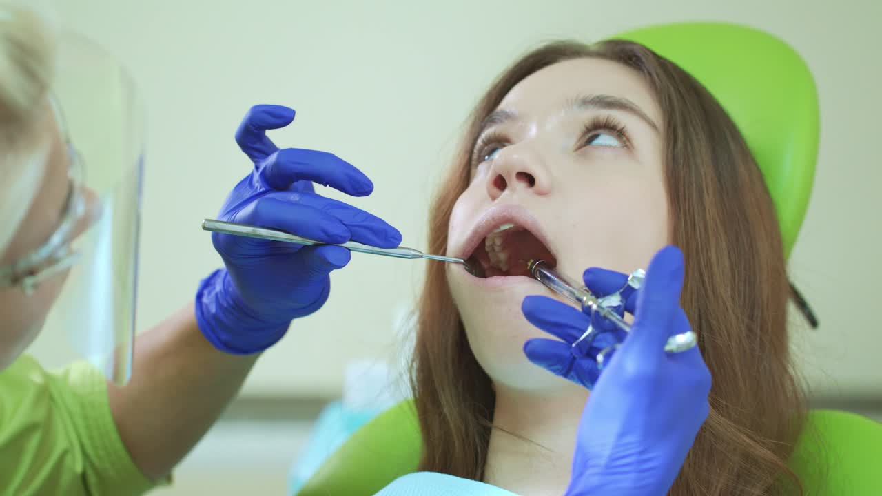 mujer joven con la boca abierta durante un procedimiento dental. inyección anestésica