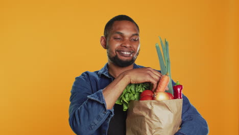hombre afroamericano presentando una manzana verde recién cosechada