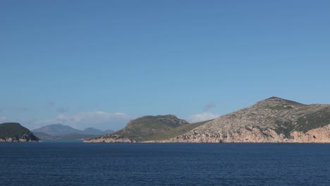 panning shoot of mountain islands in the meddle of the tyrrhenian sea of sardinia with blue sky
