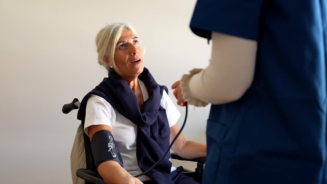Nurse Checking Senior Woman's Blood Pressure