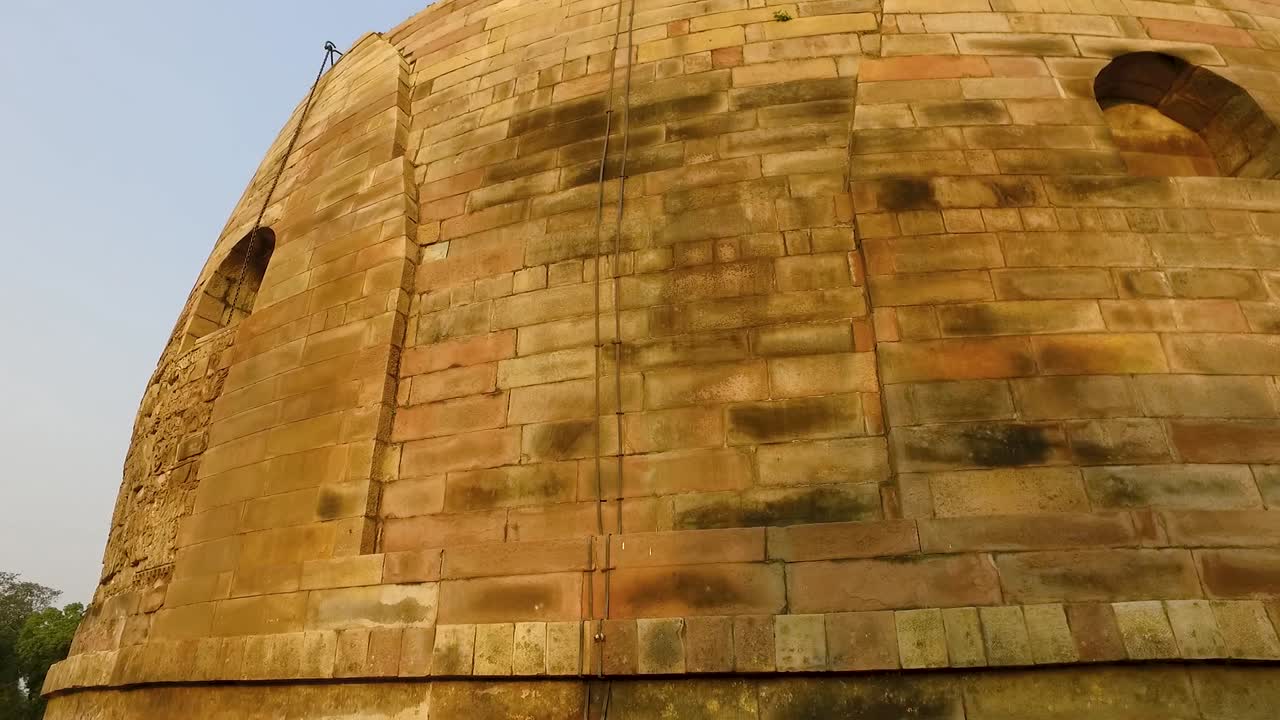 Il bellissimo e antico Stupa di Dhamek a Sarnath, India, con intagli floreali sulla parete di pietra in panoramica verso il basso