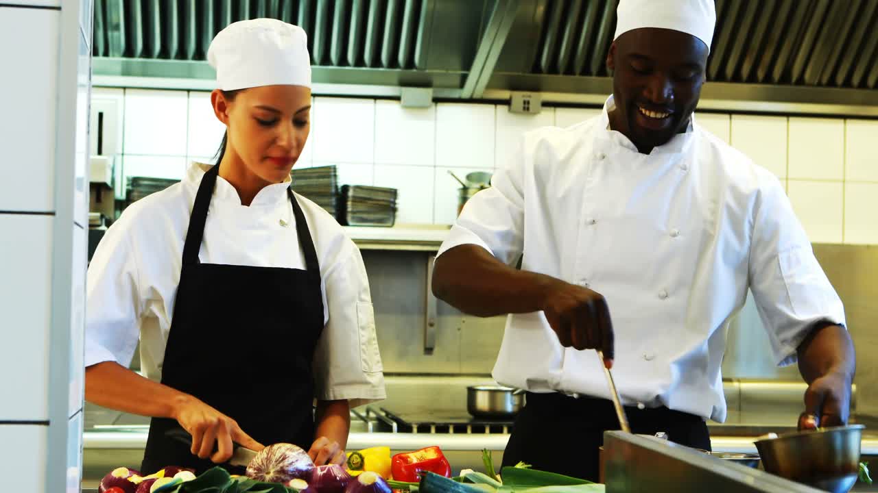 cocineros preparando comida en la cocina comercial