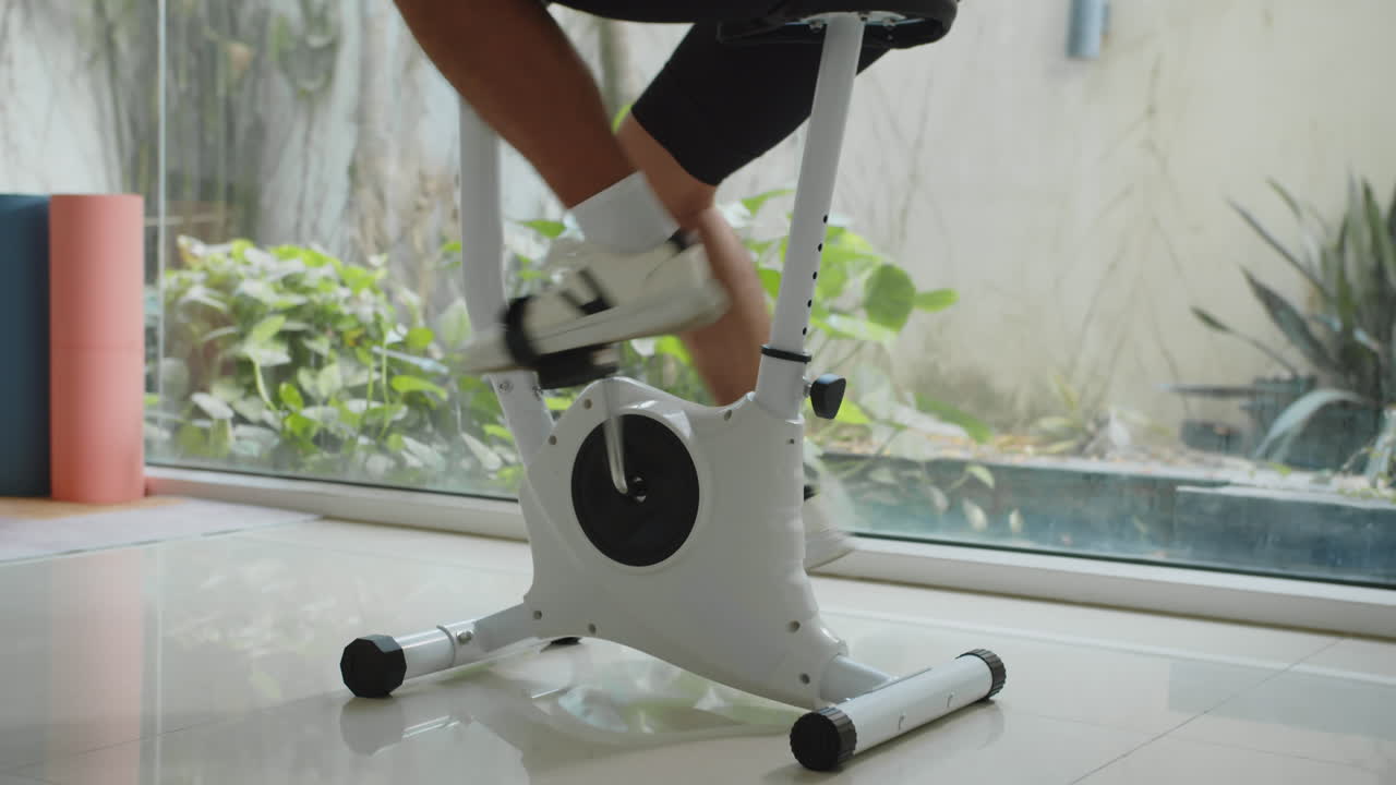 Legs of Man Exercising on Fitness Bike