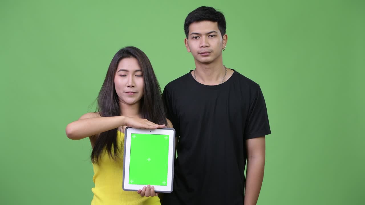 Young Asian couple showing digital tablet together