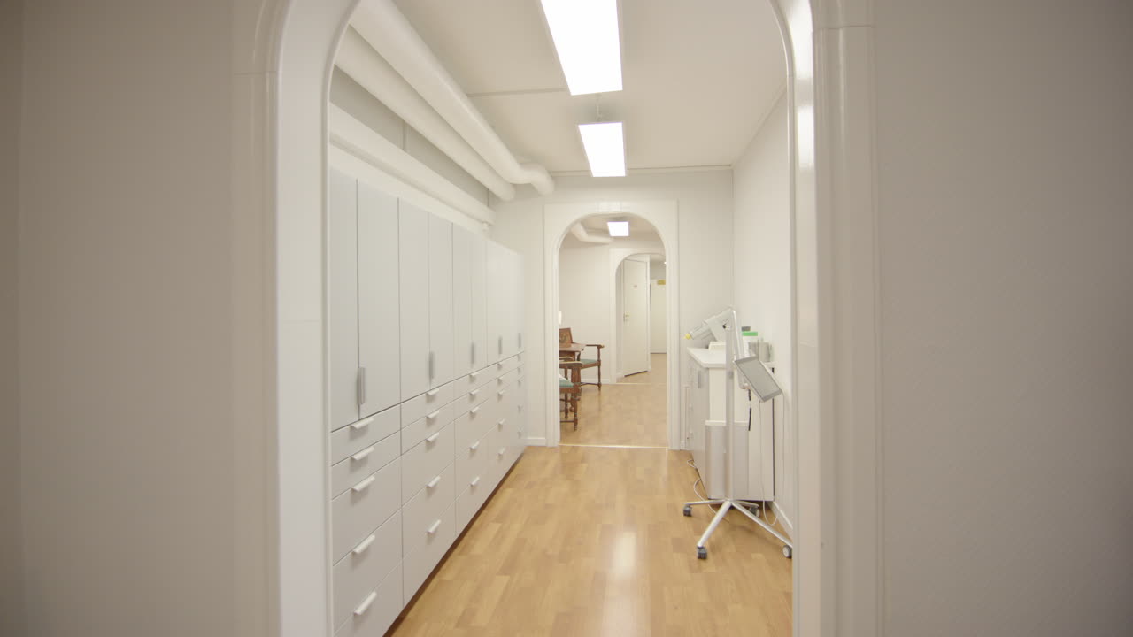 POV walking down modern lit up corridor of health centre, gimbal dolly