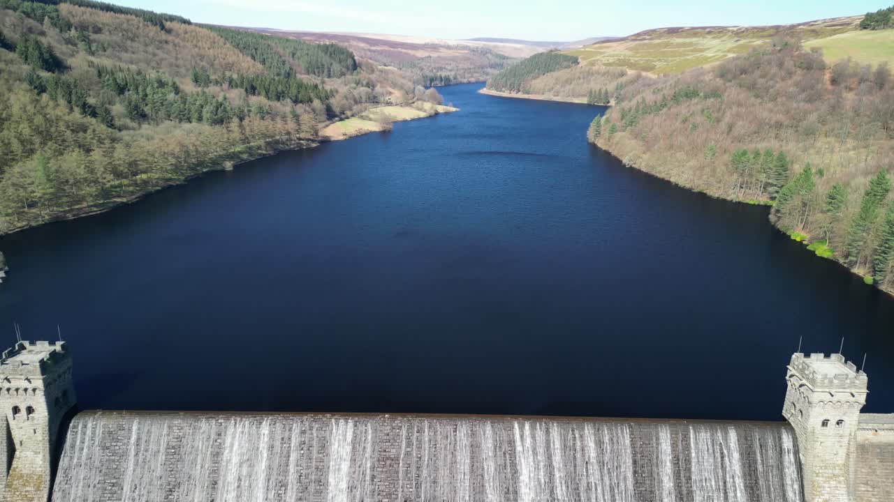 Aerial tilt up from the Derwent Dam to reveal the Derwent Reservoir and landscape, home of the Dam Busters practice during the second world war