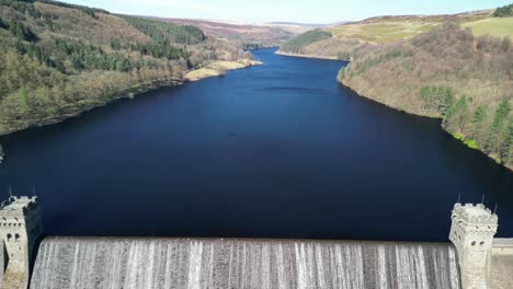 aerial tilt up from the derwent dam to reveal the derwent reservoir and landscape, home of the dam busters practice during the second world war