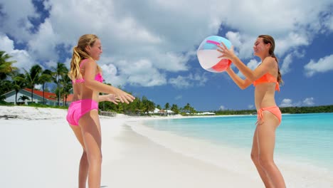 caucasian girls in swimwear having fun with ball