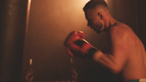 Shirtless-Boxer-Male-Warms-Up-By-Hitting-The-Punching-Bag