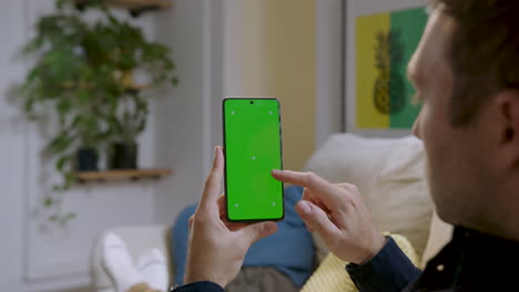 man's finger scrolling on mobile phone with green screen - chroma key