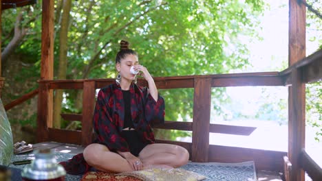 woman enjoying a drink on a wooden deck