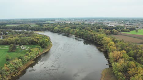 aerial shot moving down a wide river on an overcast day