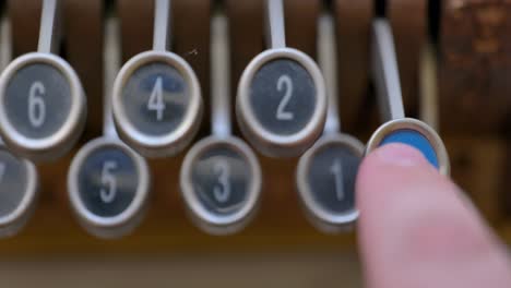 pushing the paid out button or latch on an antique cash register