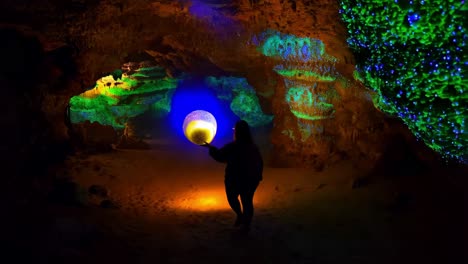 person with lantern in a glowing cave