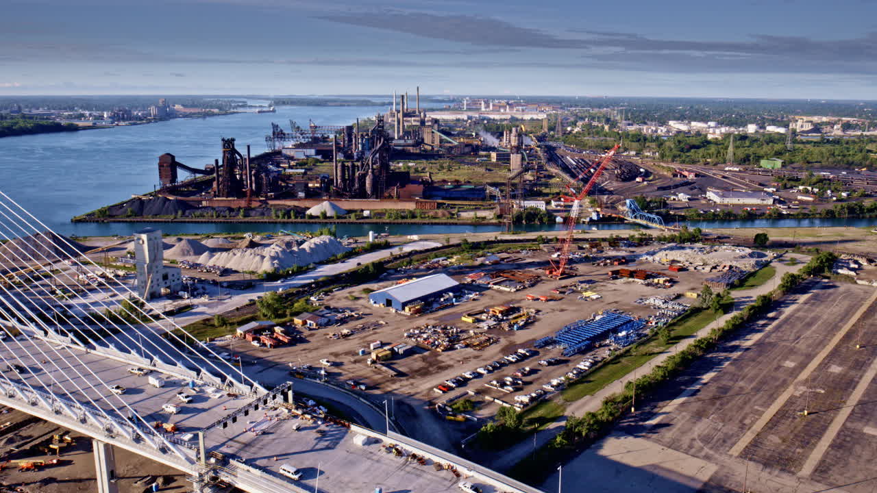 Drone footage soaring above the Gordie Howe Bridge toward factories lining the Detroit River