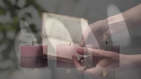 Composite-video-of-burning-candles-against-woman-hands-holding-bible-and-rosary-praying