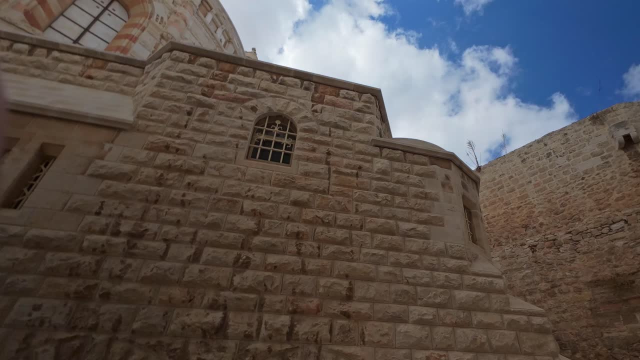 Vista in hyperlapse della parete in pietra ruvida e della finestra ad arco dell'abbazia della Dormizione a Gerusalemme