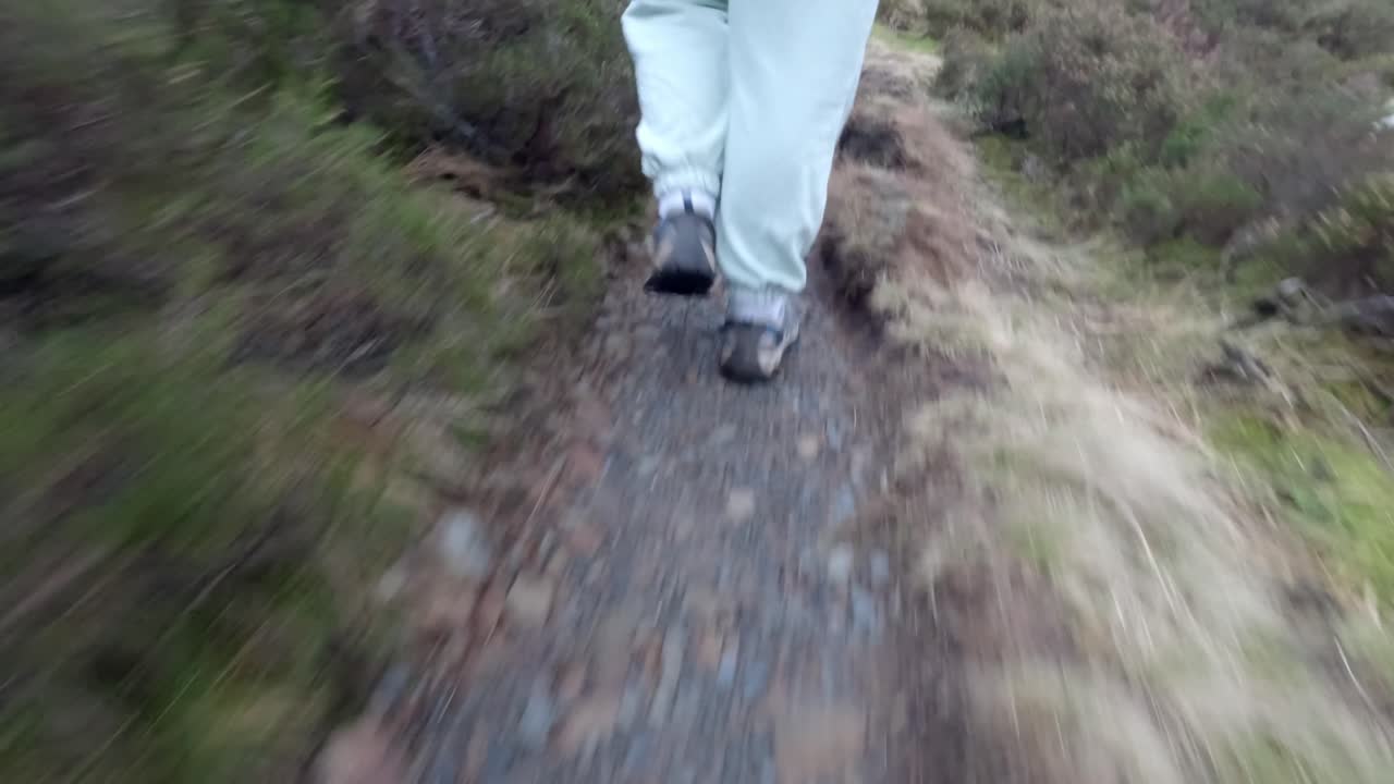 회색 암말 트레일의 험준한 산악 지형을 하이킹할 때 여성의 발을 낮게 쐈습니다.