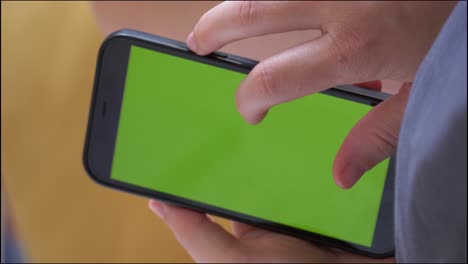 Vertical-video-Close-up-Caucasian-hand-scroll-on-green-screen-on-mobile-phone